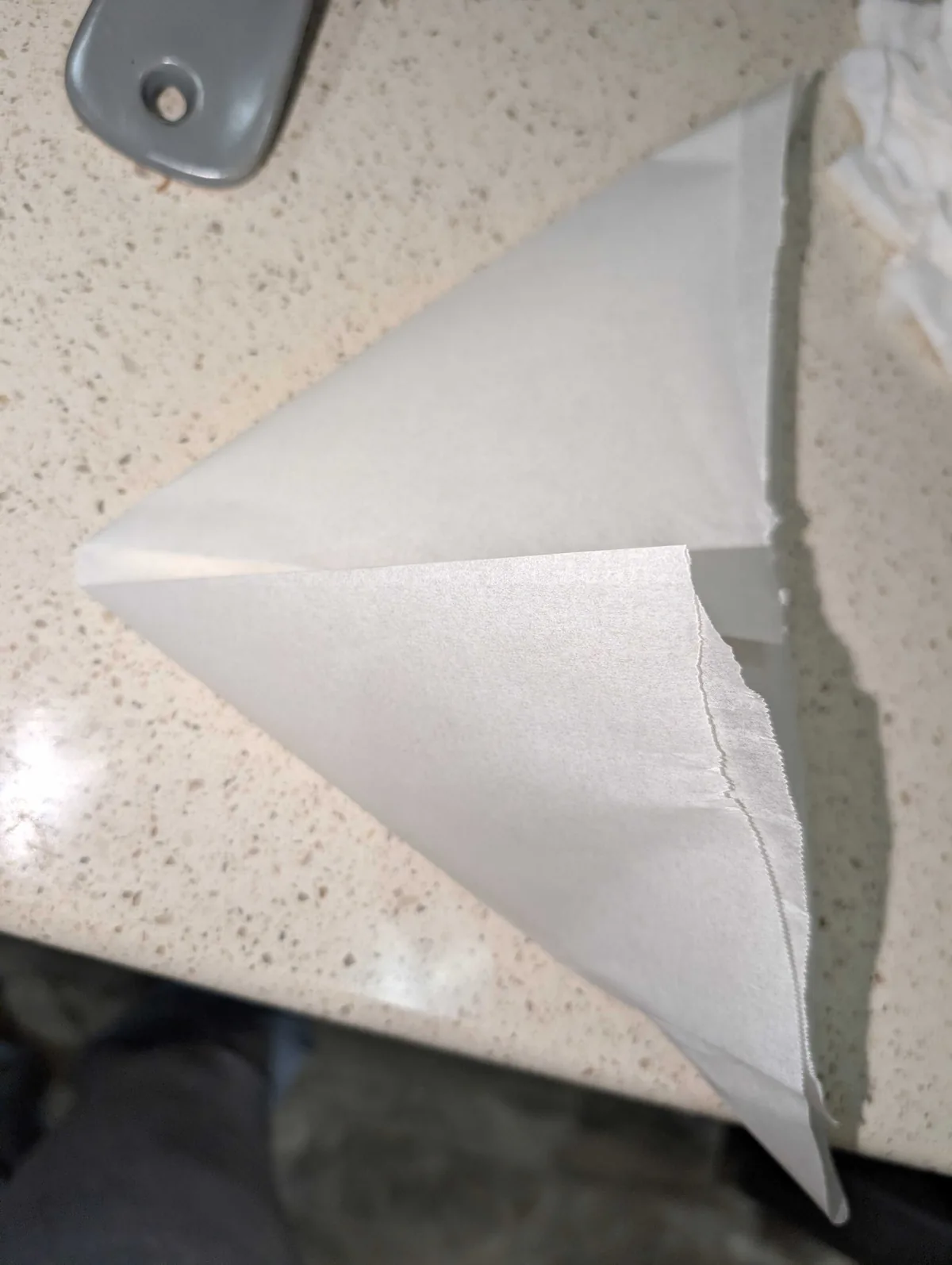 A square of parchment folded into a triangle on the counter