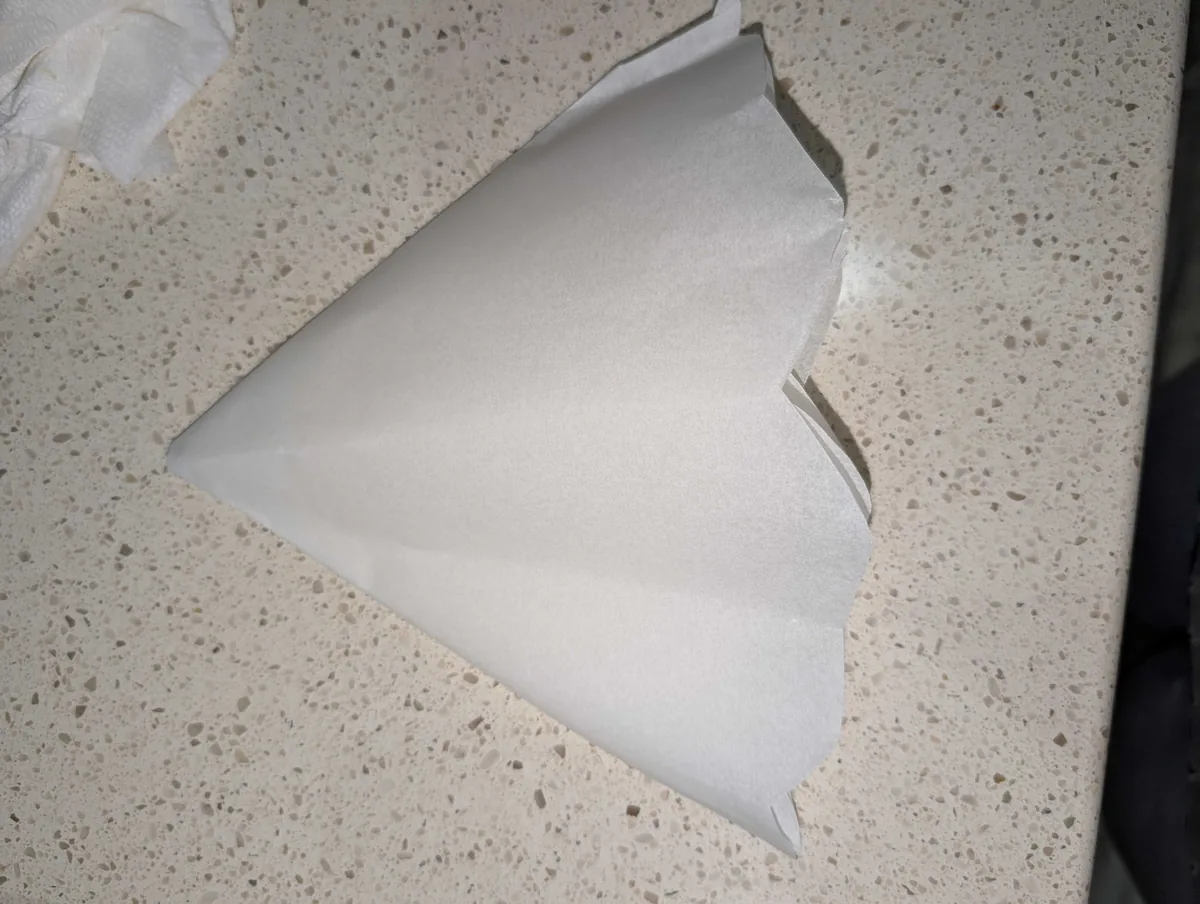 The folded parchment wedge with its wide end trimmed into a curve