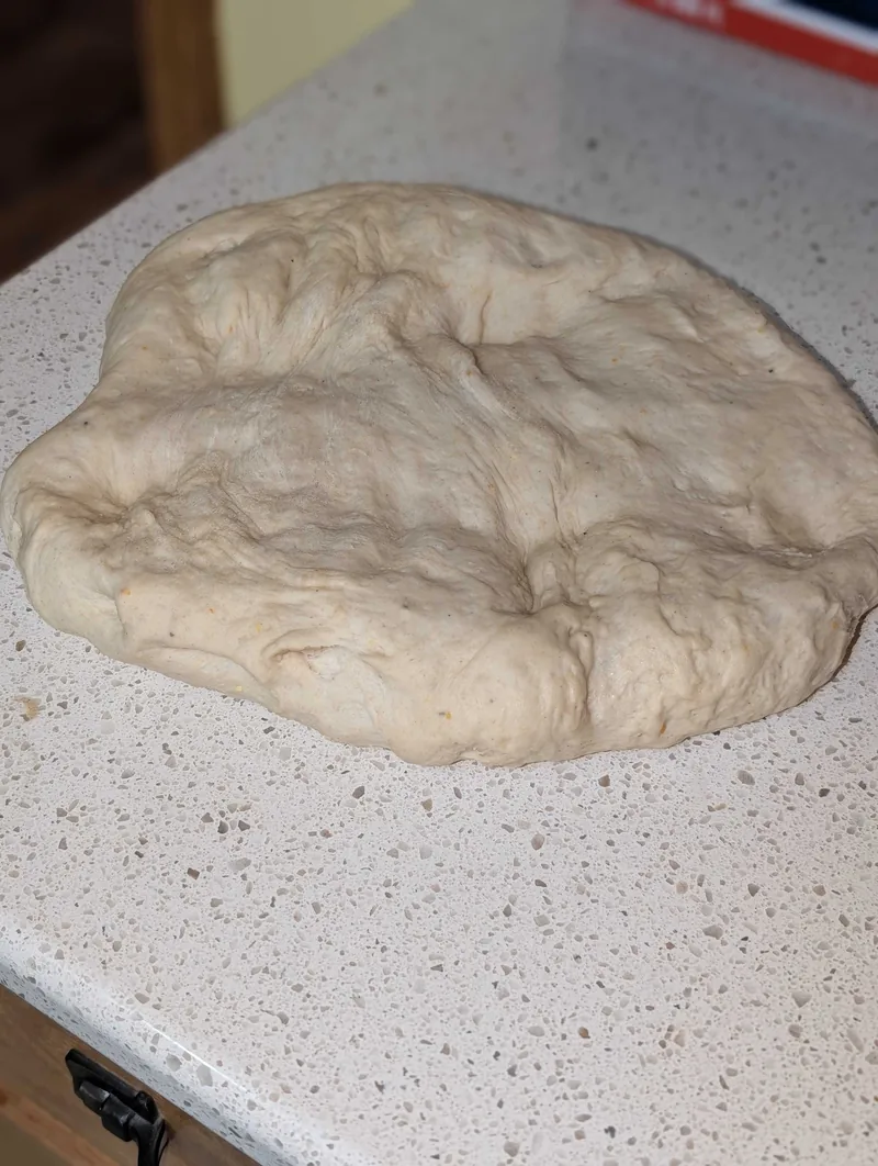 The risen dough turned out onto the counter, ready to shape into a boule