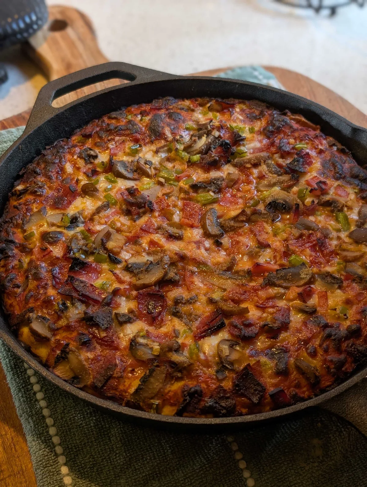 The supreme pizza still in its cast iron skillet, the cheese charred at the edges and loaded with pepperoni, salami, mushrooms and peppers